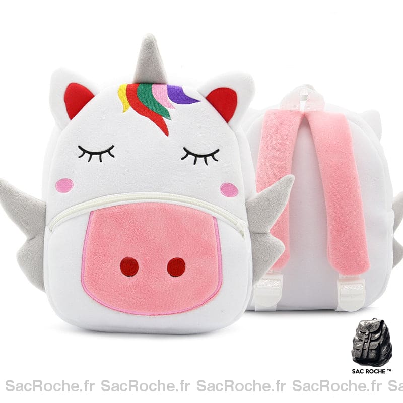 Sac à dos d'écolier en velours en forme de tête de licorne blanche avec une petite crinière multicolore et le museau rose, présenté de face et en arrière plan , le sac est également présenté de dos, où l'on voit les lanières roses