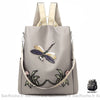 Sac à dos brodé motif fleur et papillon pour femme beige et gris avec un fond blanc