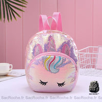 Sac à dos enfant à sequins licorne rose avec un fond une tasse de chat blanche, un panier blanc, et un fond rose