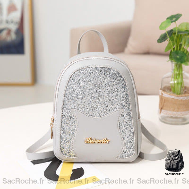 Mini sac à dos à paillette pour fille gris avec un fond une table blanche avec un fond un canapé beige