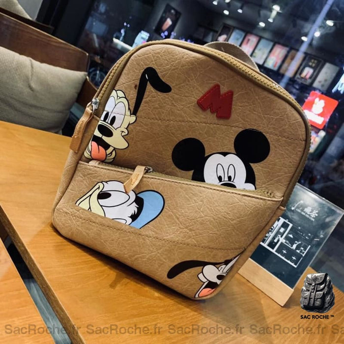 Mini sac à dos Mickey Mouse pour enfant beige avec un fond une table en bois