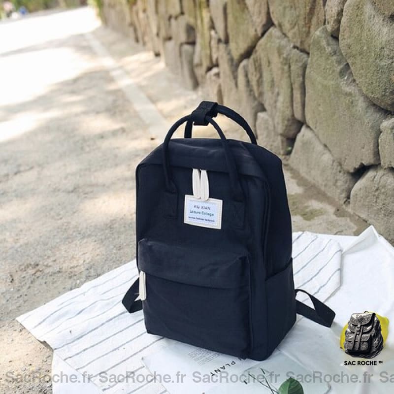 Sac à dos en toile pour ordinateur 15 pouces bleu avec un fond une table blanche et un mur en pierre