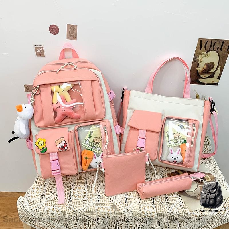 Sac à dos en tissu Oxford quatre pièces avec porte-clés peluche rose avec un fond une table avec d'autres objets