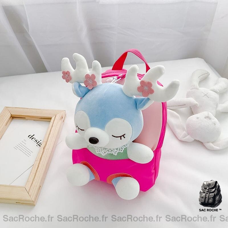 Sac à dos d'école en peluche pour enfant rose dans un lit blanc et une peluche blanche sur le côté