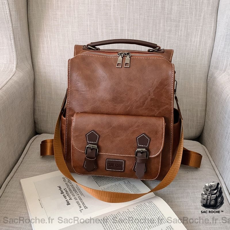 Sac à dos vintage en similicuir marron avec un fond un canapé beige